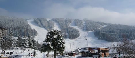 Vue du pied de l'immeuble, côté commerces et pistes.