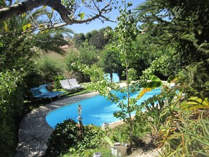 Piscine et transats avec   
 jardin arboré