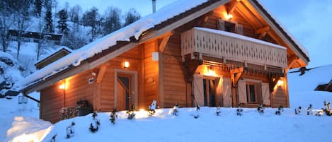 Chalet en hiver à la tombée de la nuit