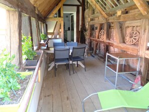 La terrasse couverte du gite du 1er étage. Au fond la porte d'accès à la cuisine