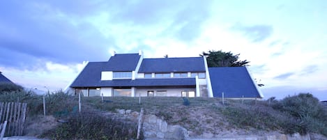 grande maison surplombant la plage et la mer. 