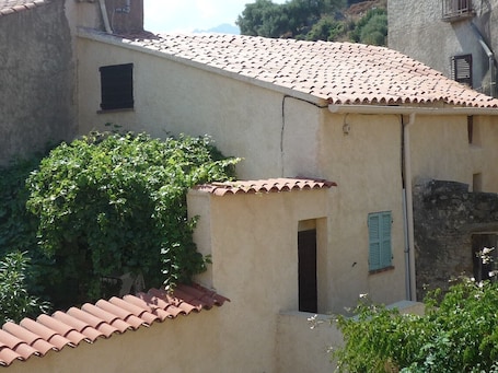 Vue de la maison : on aperçoit la treille ombragée de la terrasse.