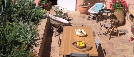 Vue d'en haut, la terrasse  principale avec la grande table et le coin détente.