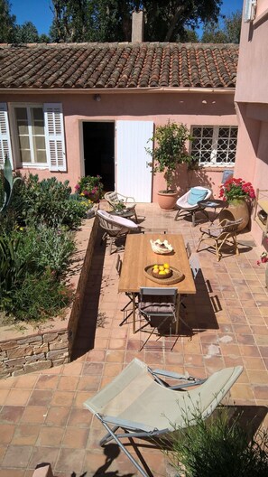 Vue d'en haut, la terrasse  principale avec la grande table et le coin détente.
