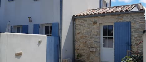 Façade de la maison avec stationnement devant le mur en pierre