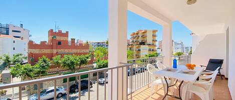 Terrasse avec store, 1 chaise longe et table et chaises pour manger.