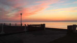 Vue du salon. Le soleil vient de se coucher et continue de colorer le ciel 