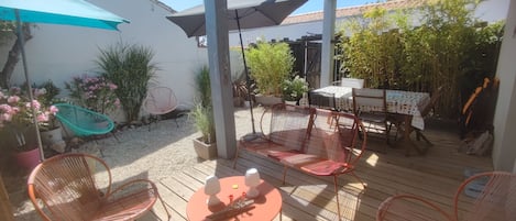 Terrasse fleurie avec 2 transats sécurisée et fermée avec douche extérieure