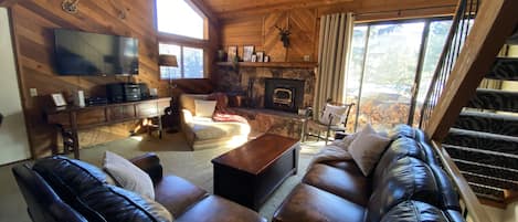 Living room with wood burning fireplace & balcony w/ stocked wood (2nd floor). 