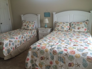 Bedroom with twin and full beds on first floor next to laundry 