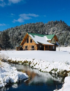 Cabin after a snowfall. Tranquil creek runs through the property.