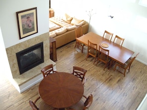 View from upstairs looking down on the dining table, fireplace and game table.