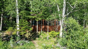 Picture of the cabin from the dock - trees keep the house cool on hot days