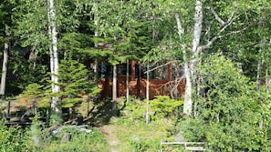 Picture of the cabin from the dock - trees keep the house cool on hot days