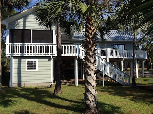 Bayside view of our one-story home with screened porch and wraparound deck. 