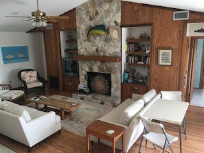 Living room w/ vaulted ceiling, comfortable large sofas. Pecky cypress bookcase.