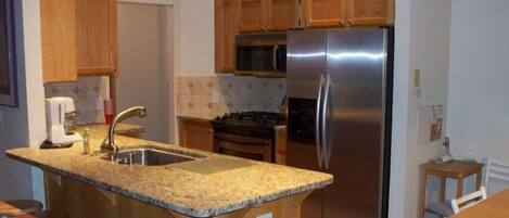 Updated kitchen with granite counters and stainless steel appliances.