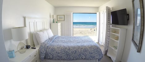 Master Bedroom overlooking ocean   with blue print bedspread