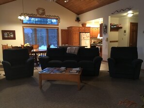 Living room seating facing stone fireplace and new 50” smart TV. 