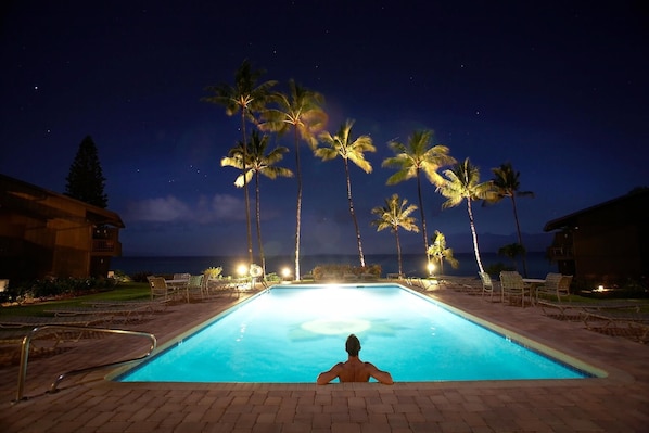 The beautifully lit pool at night.