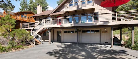 Front of cabin with driveway, 2 car garage and front decks