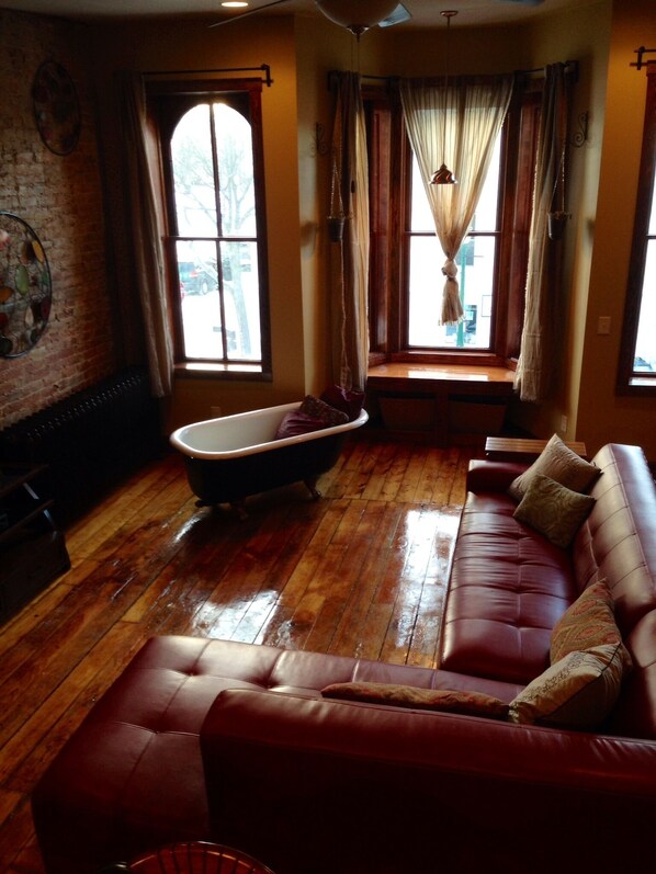 View of living room from loft beds. Windows look out onto the Courthouse.