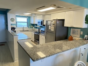 Fully stocked kitchen with granite countertops and stainless appliances