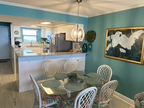 View of front door and kitchen from TV area