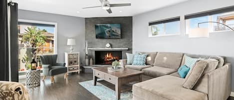 Main upper level living room of front main house, with ocean views, comfy seating, TV, fireplace. Access to front ocean view balcony and outdoor seating.