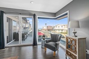 Main upper level living room, with ocean views, comfy seating, TV, fireplace. Access to front ocean view balcony and outdoor seating, just 3 houses from the 40th Street beachfront.