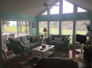 Living room with glimpse of golf course and deck.