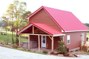 front view of the cabin and front porch with hot tub