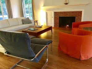 Living room with designer furniture, gas log fireplace, flat screen TV, views