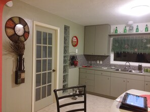 kitchen and glass door going in the room with twin bed