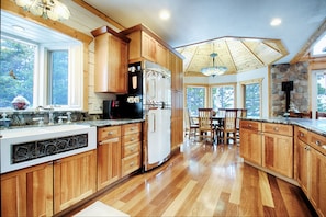 Huge fridge, apron-front sink, well-stocked cherry cabinets open to dining room.