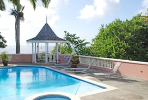 Another view from the patio of an imperial palm, pool, gazebo, and Caribbean sea
