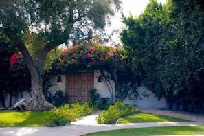 Charming main entrance, covered in bougainvillea, and steps away from downtown...