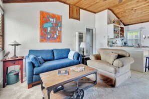 Larger view of living room with couch and very cozy chair