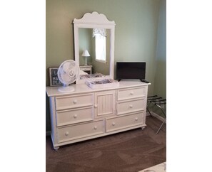 Master bedroom includes dresser with flat screen tv.