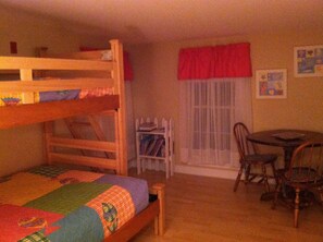 The bunkroom is outfitted with a double & single bed and a table and chairs.