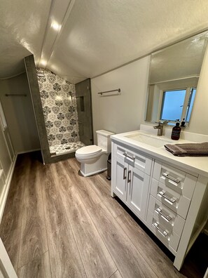 Spacious bathroom with shower and beautiful accent tile wall