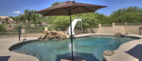 Heated, salt water, pebble tech pool with swim-up-table, slide and diving board