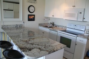 Well-appointed kitchen w/oversized granite bar dining counter!  Full size range.