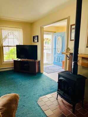 Living room has a small gas fireplace for t chilly nights and a large screen TV.