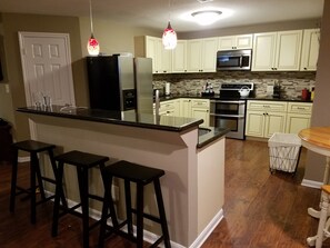 Large open kitchen with bar seating and bistro table