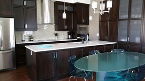 Elegant dining at frosted glass table.  Fully -equipped kitchen