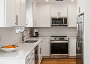 New kitchen with custom cabinets, quartz counters and an induction range. 