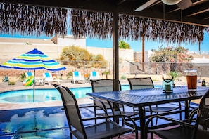Backyard with Baja Shelf Pool, Spa, Large Covered Patio w/ Outdoor Dining table.