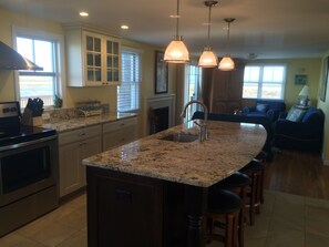 New large granite island with seating for 4 overlooking pond