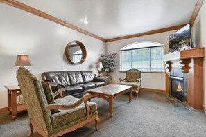 Livingroom features a cozy fireplace and leather sofa